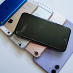 Starý iPhone položený na stôl vedľa peňazí pripravený na výkup.