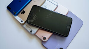 Starý iPhone položený na stôl vedľa peňazí pripravený na výkup.