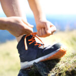 Turista odpočívajúci s vyzutou turistickou obuvou po dlhej túre.