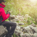 Turista prechádza kamenistým horským chodníkom v náročnom teréne