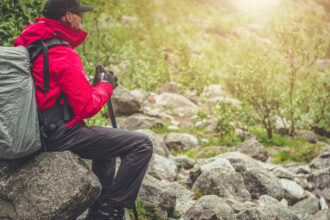 Turista prechádza kamenistým horským chodníkom v náročnom teréne