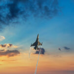 Prúdová stíhačka počas vzletu z letiskovej dráhy v slnečnom počasí.