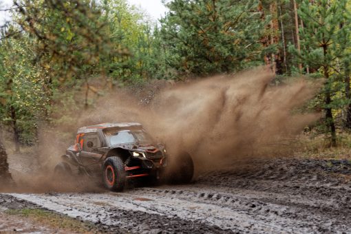 Štvorkolka jazdí v bahnitom teréne počas offroad jazdy.