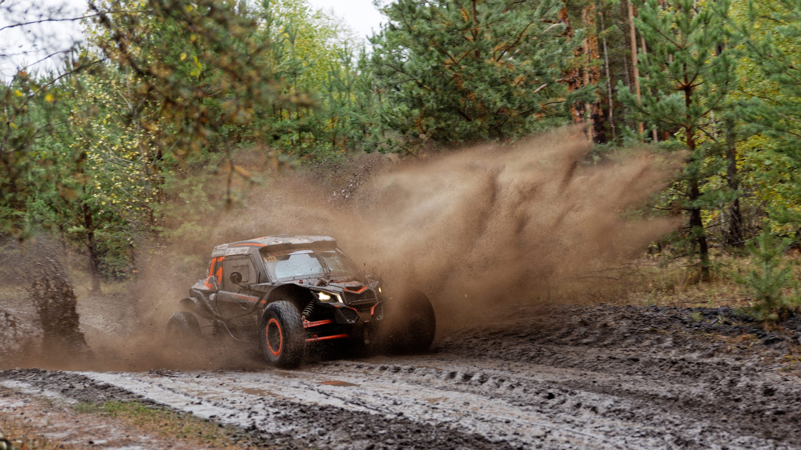 Štvorkolka jazdí v bahnitom teréne počas offroad jazdy.