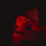 Osoba využíva red light terapiu na starostlivosť o pleť.