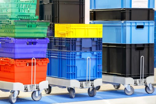 Plastové palety, prepravky a manipulačná technika používané v modernej skladovej logistike.